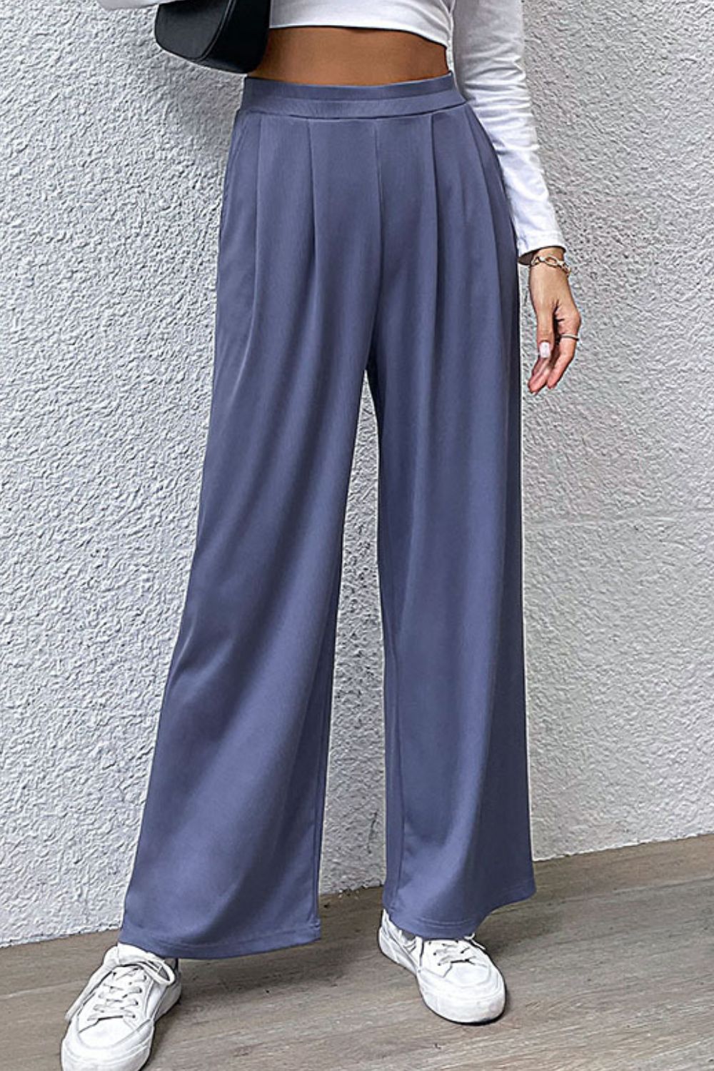 Pantalones anchos con detalle plisado y bolsillos